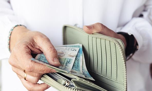 Woman taking five-pound notes out of purse